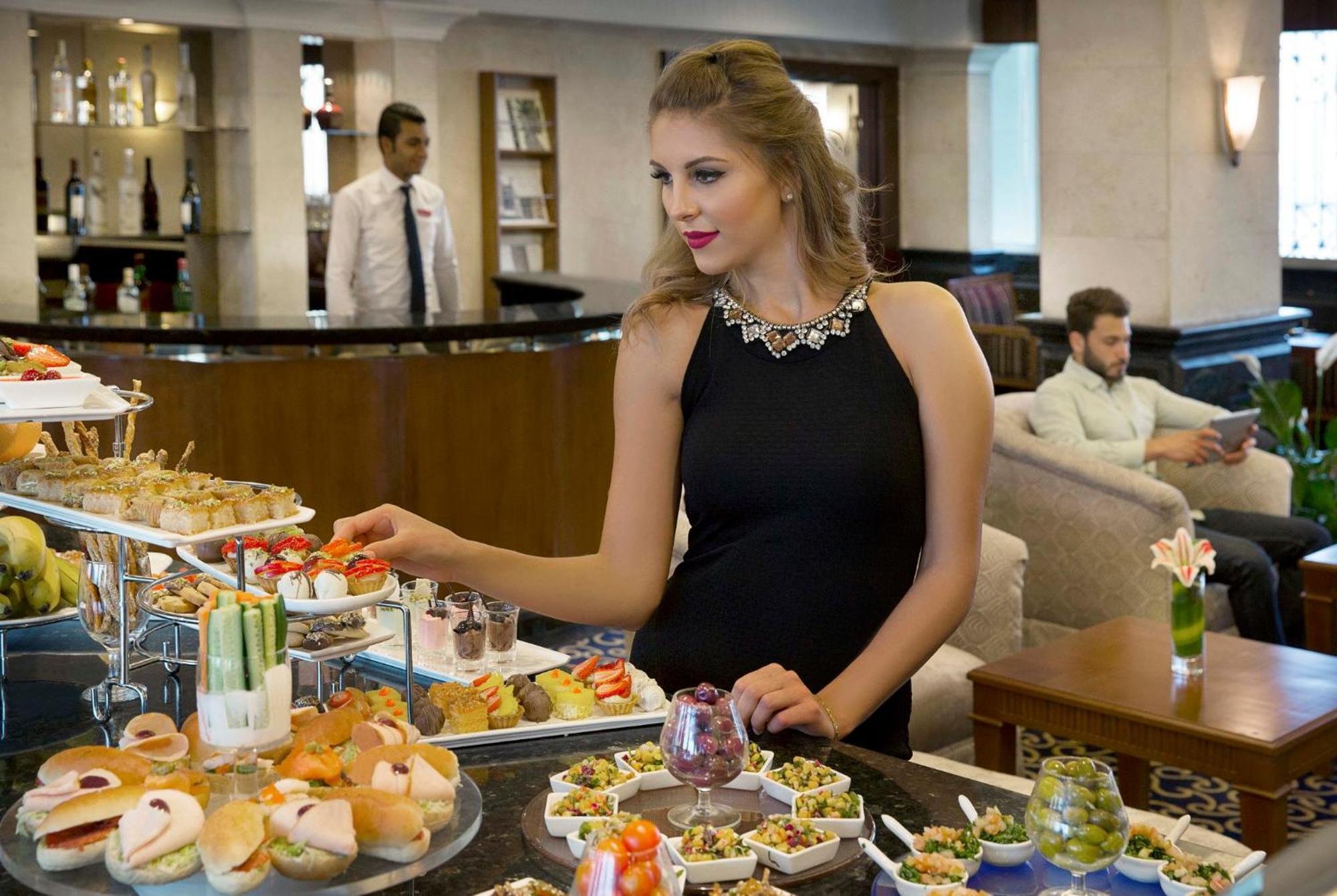 Crowne Plaza Amman By Ihg Hotel Kültér fotó A woman selecting food from a buffet